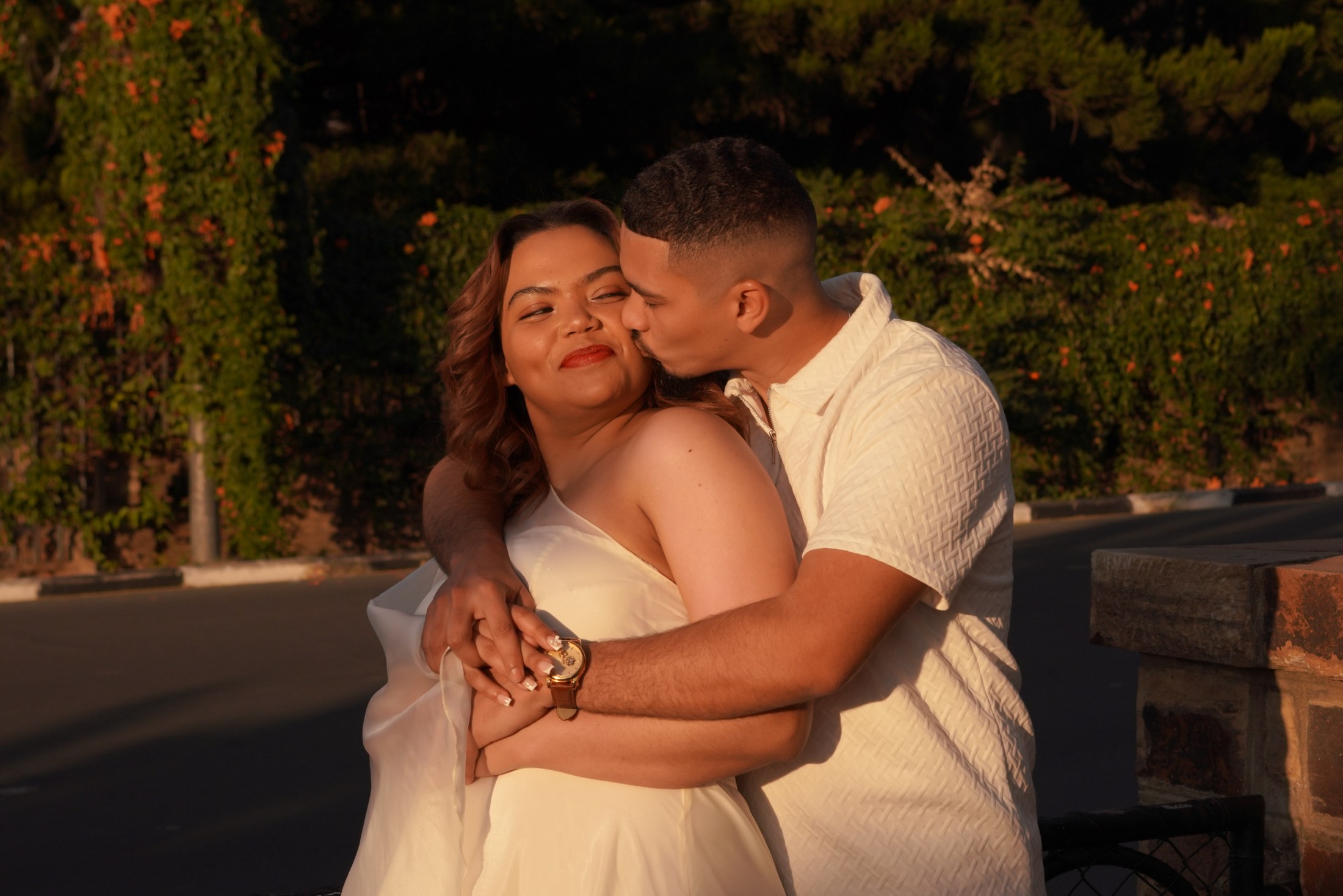 Patrick kissing Michelle on the cheek in the golden evening light